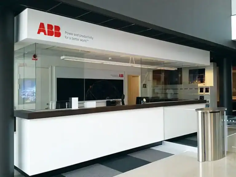 H80RG-sähköliukuluukku ABB:n asiakaspalvelutilassa Ludvikassa, vaalea tiski ja lasiseinäkehys.