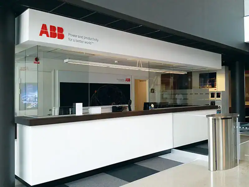 H80RG-sähköliukuluukku ABB:n asiakaspalvelutilassa Ludvikassa, vaalea tiski ja lasiseinäkehys.