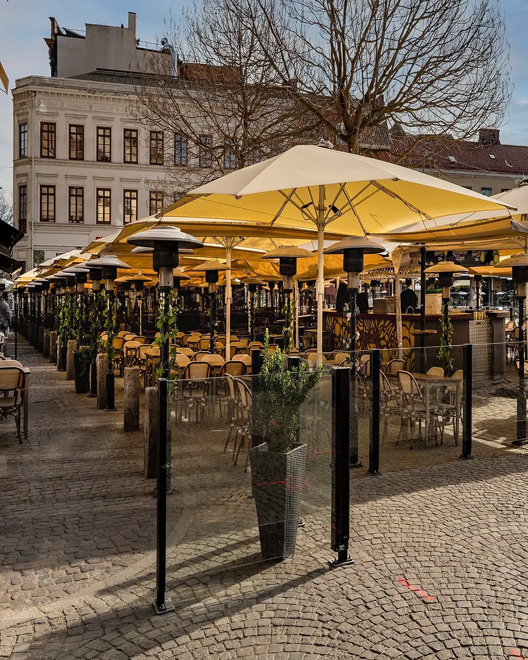 Toriterassi keltaisilla aurinkovarjoilla ja ClickitUp-tuulensuojilla