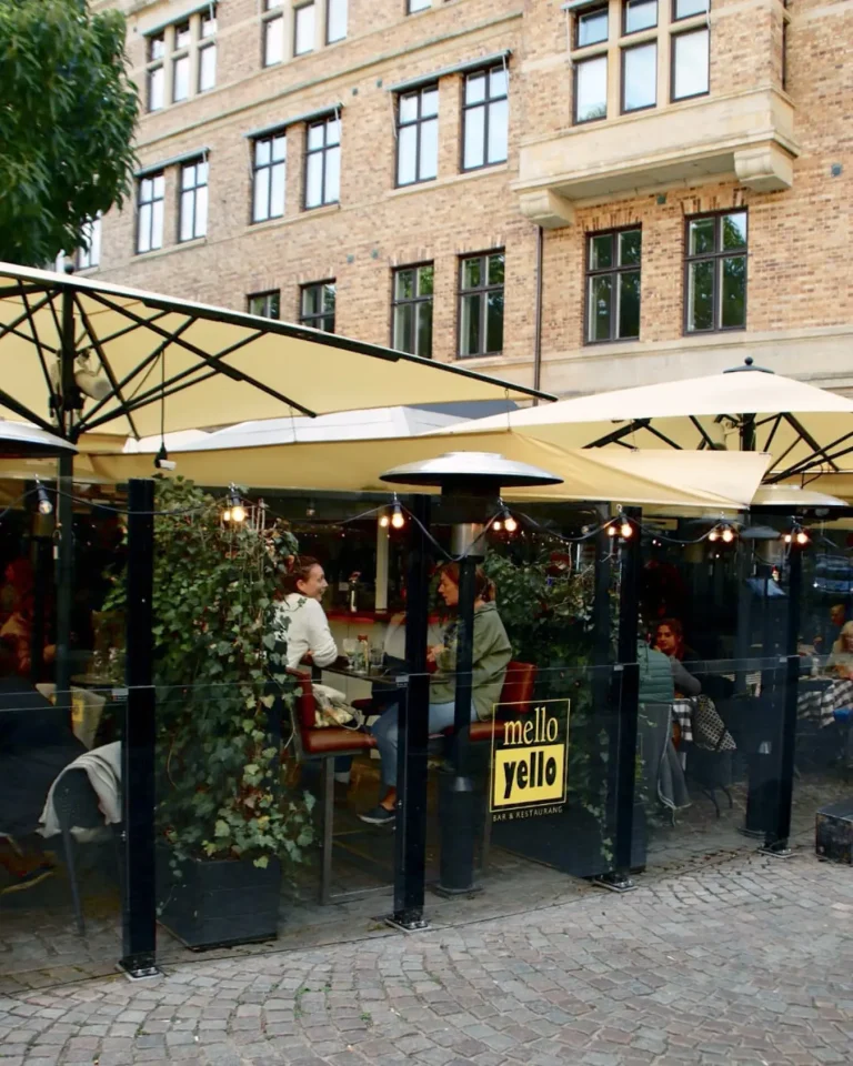 Vilkas ravintolaterassi Bahama-aurinkovarjoilla ja lasikaiteilla