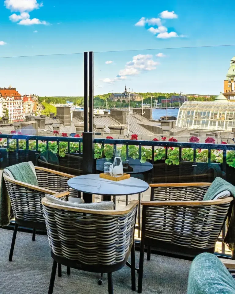 Nostettava lasikaide kattoterassilla kaupunkimaisemassa