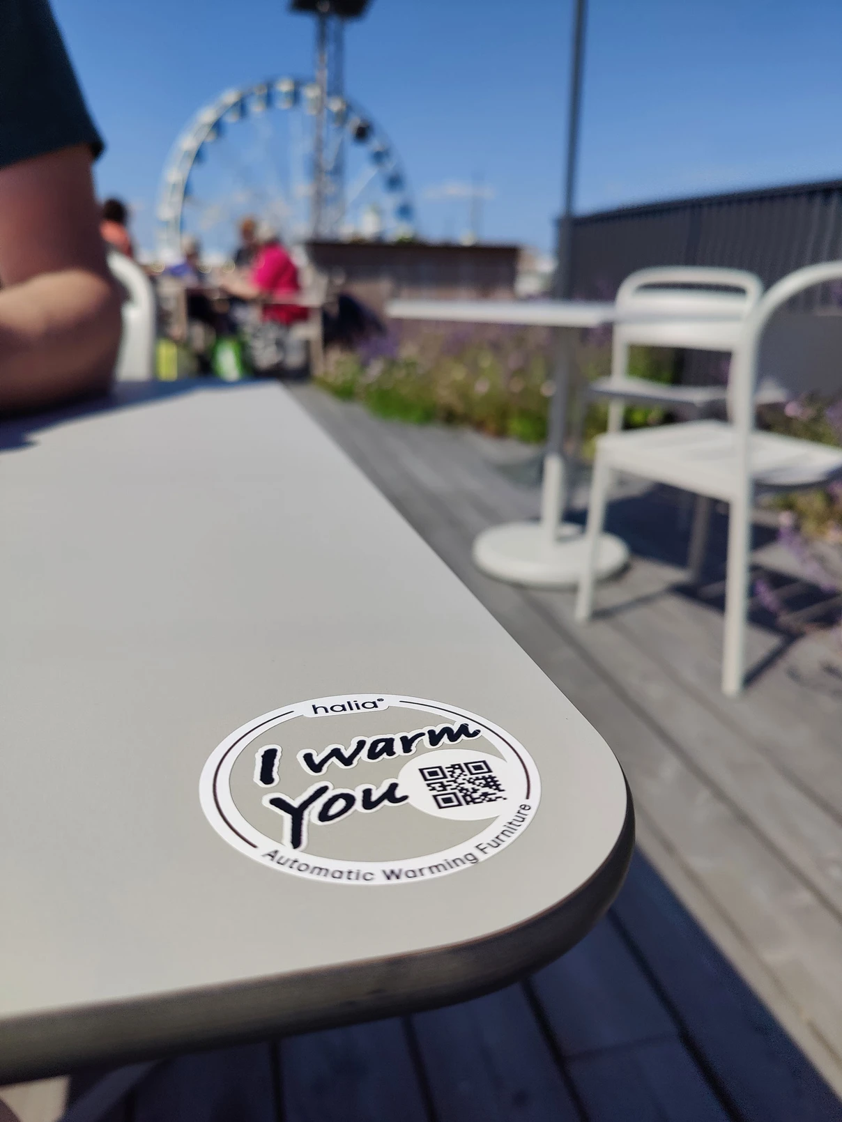 Lämmitettävä terassipöytä ulkoterassilla, pöydässä I Warm You -logo