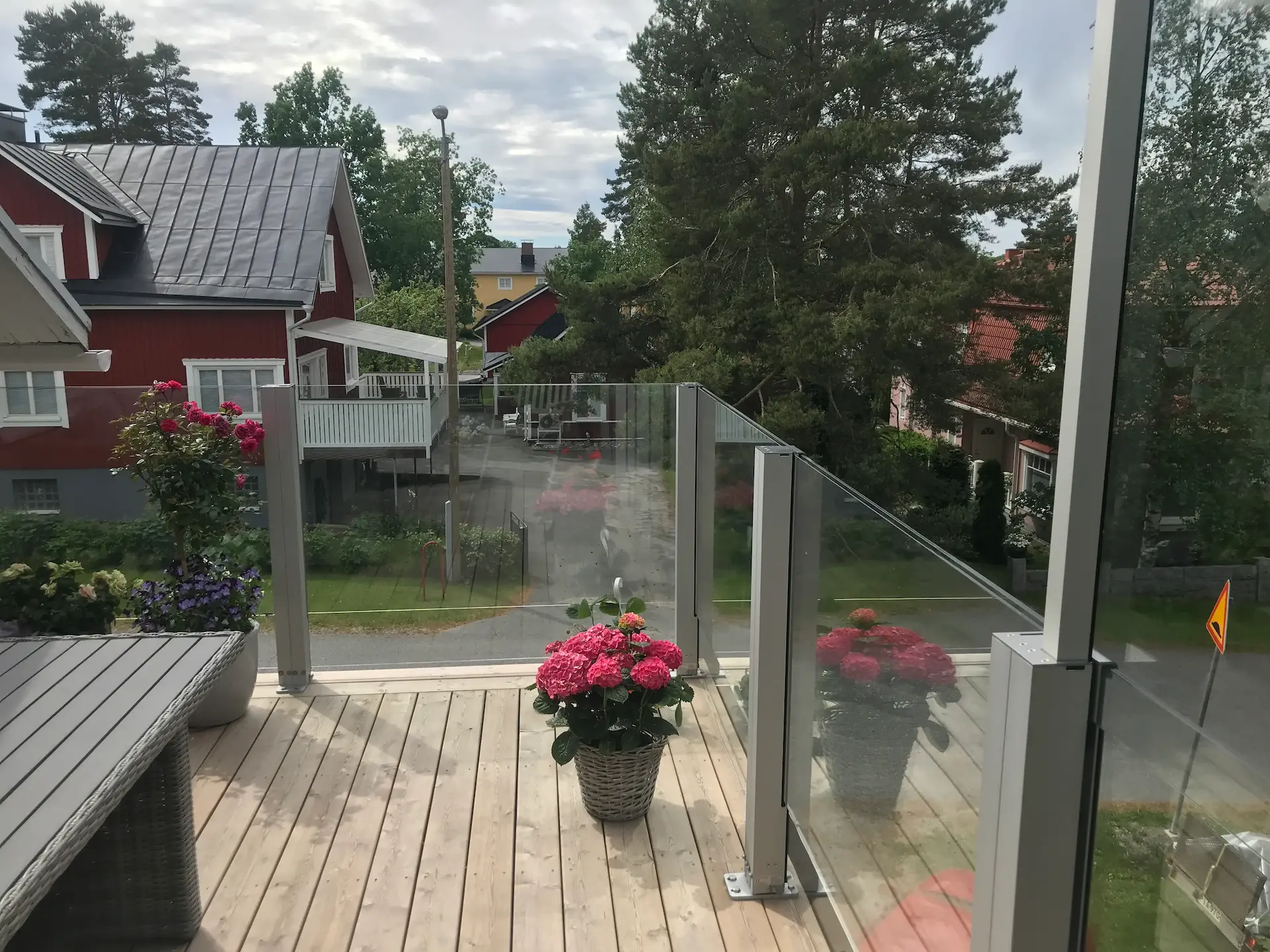 Kiinteä lasikaide yksityisellä parvekkeella, vaalea alumiinirunko.