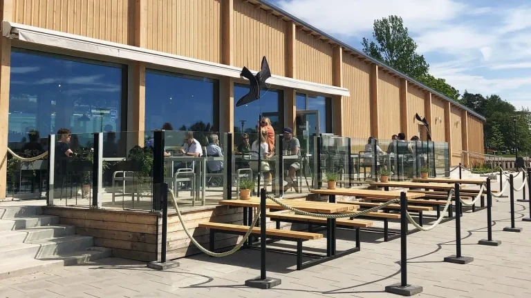 Kiinteät lasikaiteet suojaamassa kahvilan ulkotilaa