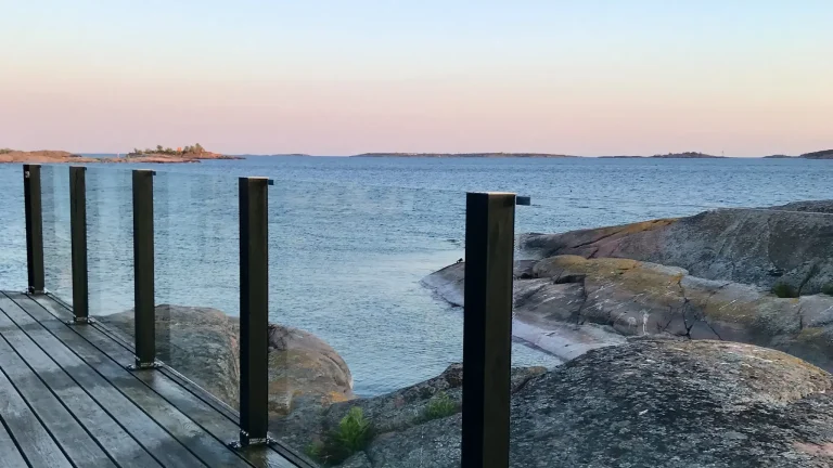 Kiinteät lasikaiteet rannan tuntumassa avonaisella kallioalueella