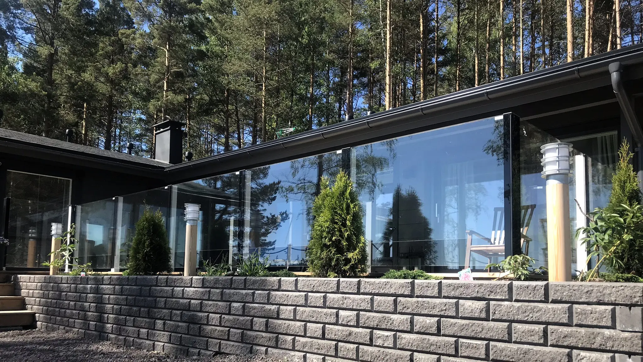 Kiinteä lasikaide kivimuurin vieressä – heijastava lasi ja harmoninen ympäristö.