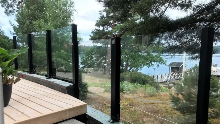 Kiinteät lasikaiteet tummilla tolpilla ja merinäkymällä