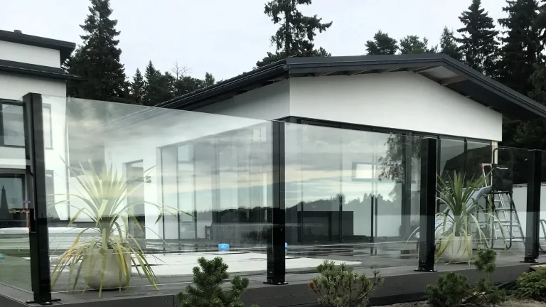 Tyylikkäät kiinteät lasikaiteet terassin ja järvimaiseman välissä