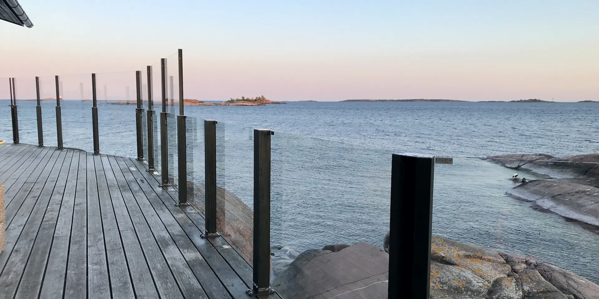 Nostettava ja kiinteä lasikaide samaa sarjaa sopuisasti terassilla meren äärellä