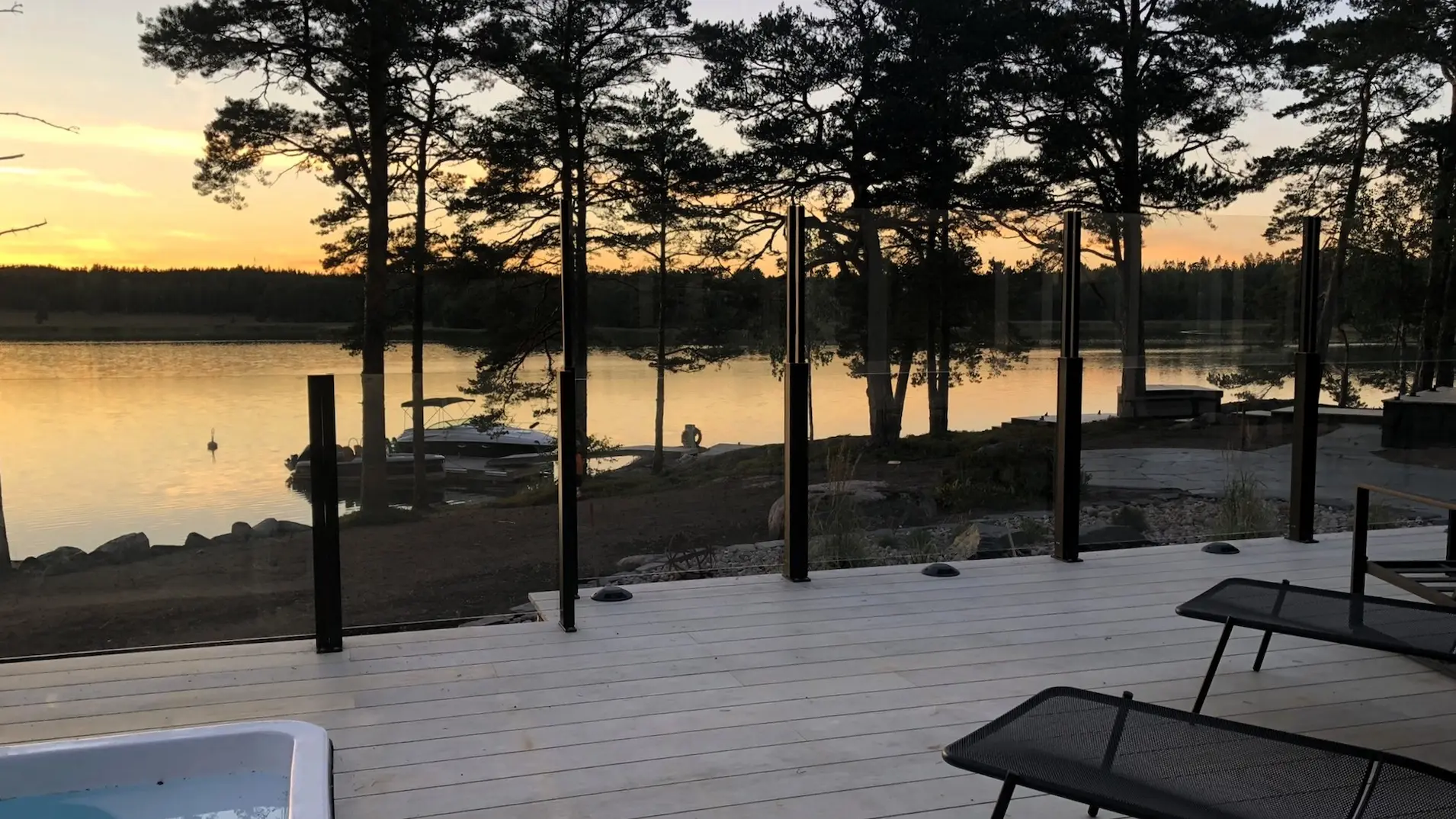 Terassi metsämaisemassa auringonlaskussa, varustettuna ClickitUp®-lasikaiteilla.