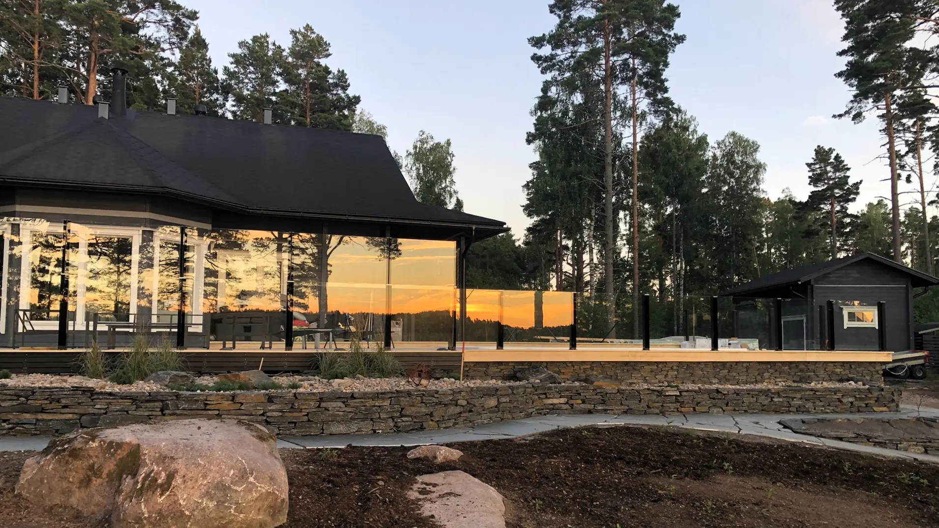 Huvilan terassi kallioisessa ympäristössä, ClickitUp®-lasikaiteet suojaamassa.